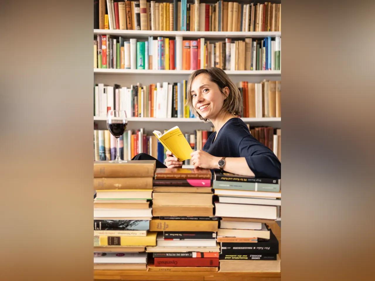 Ein Foto einer Frau, die ein Buch in der Hand hält.
