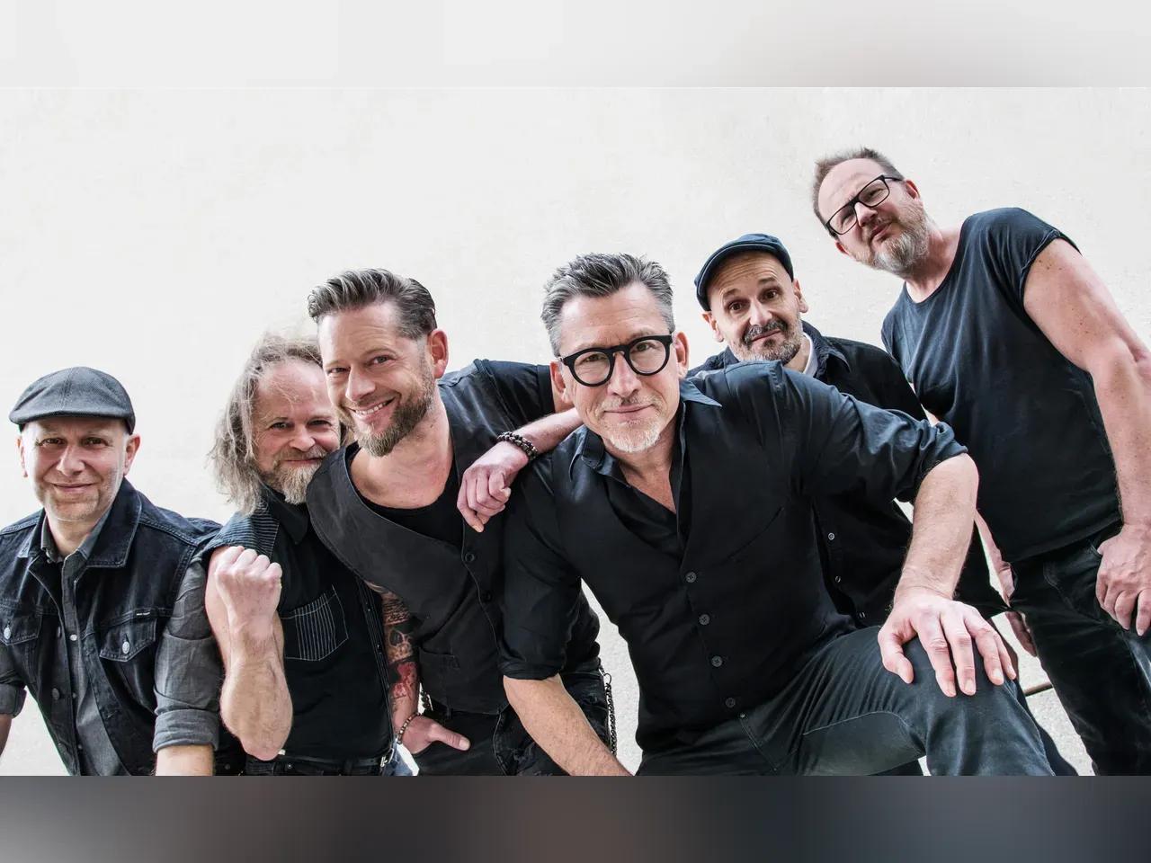 Die 6-köpfige Band Fiddlers Green vor weißem Hintergrund