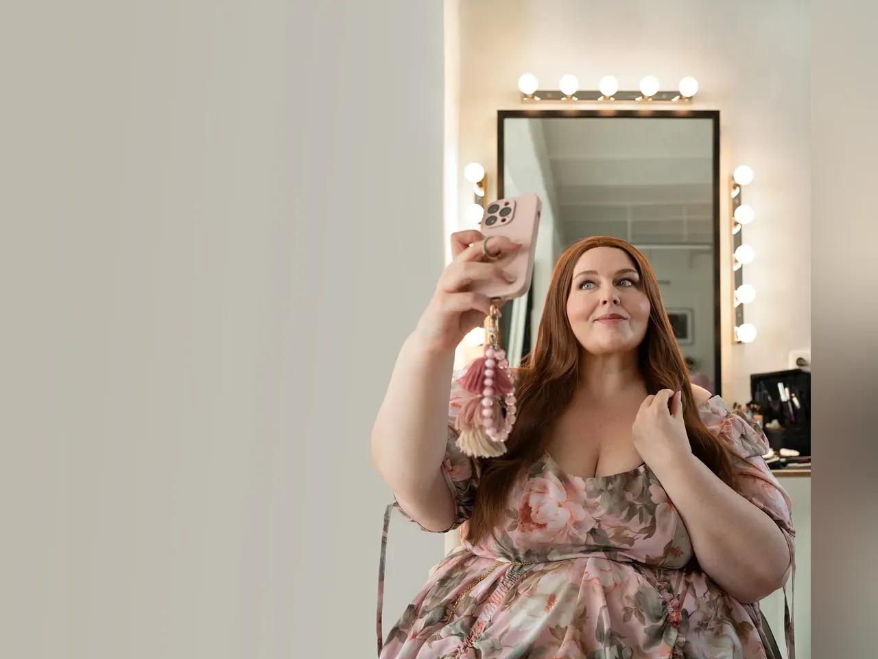 Nicole Jäger macht ein Selfie in einem schicken Kleid 