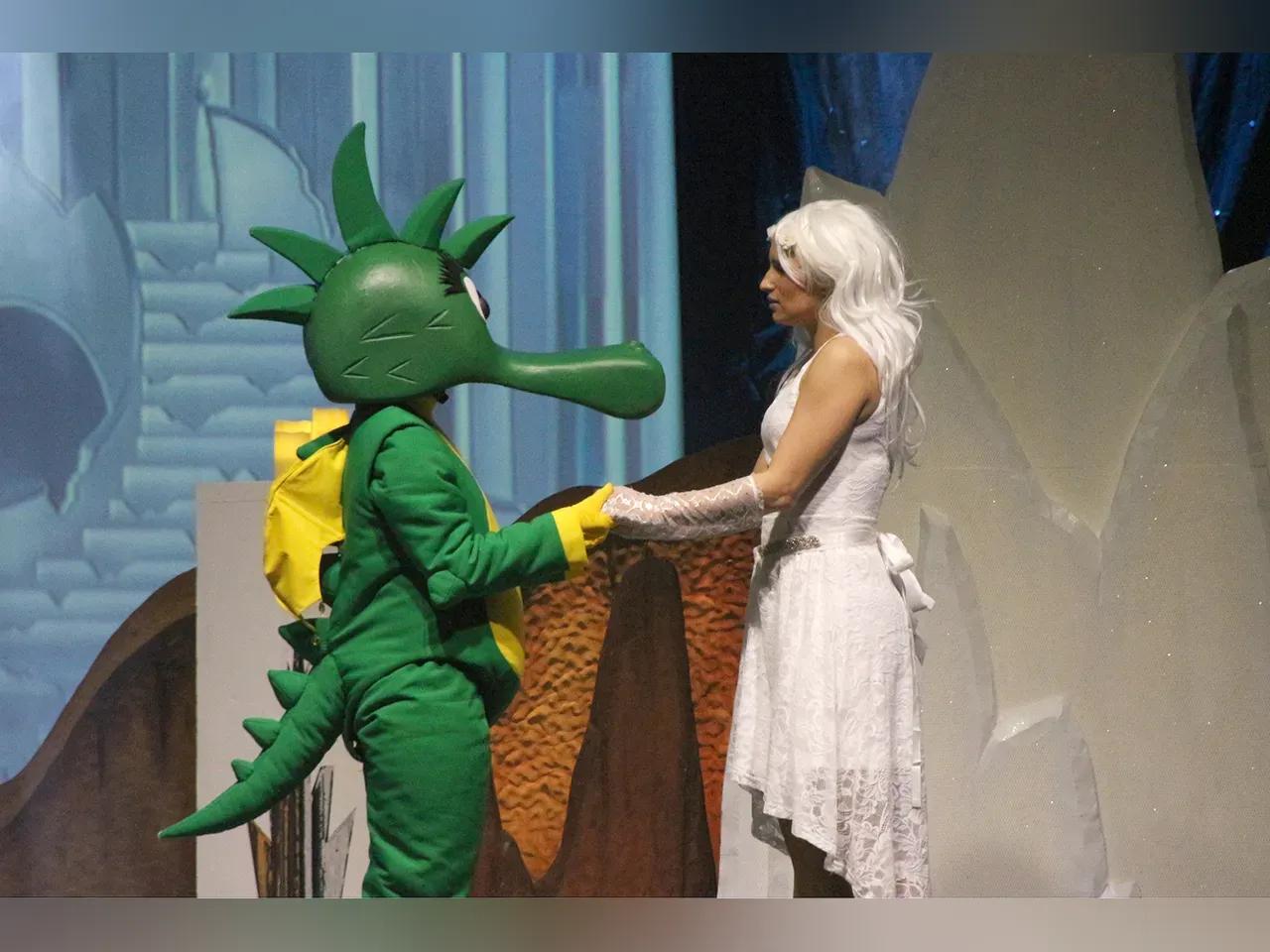 Figuren des Musicals Tabaluga und Lilli stehen Hand in Hand auf der Bühne