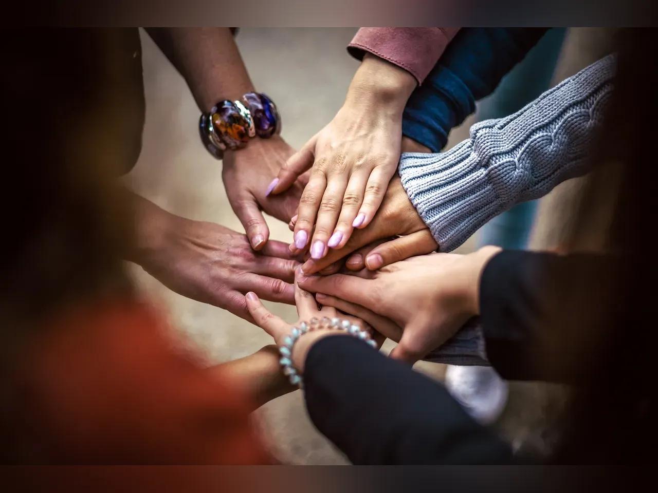 viele Hände liegen aufeinander