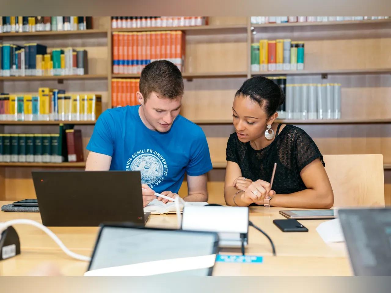 Zwei Menschen sitzen an einem Schreibtisch