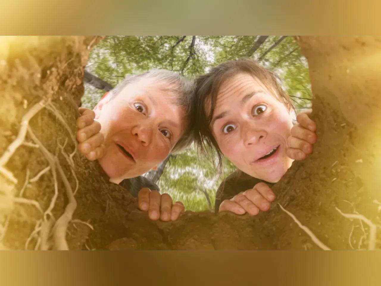 Zwei Frauen schauen in ein Erdloch hinab