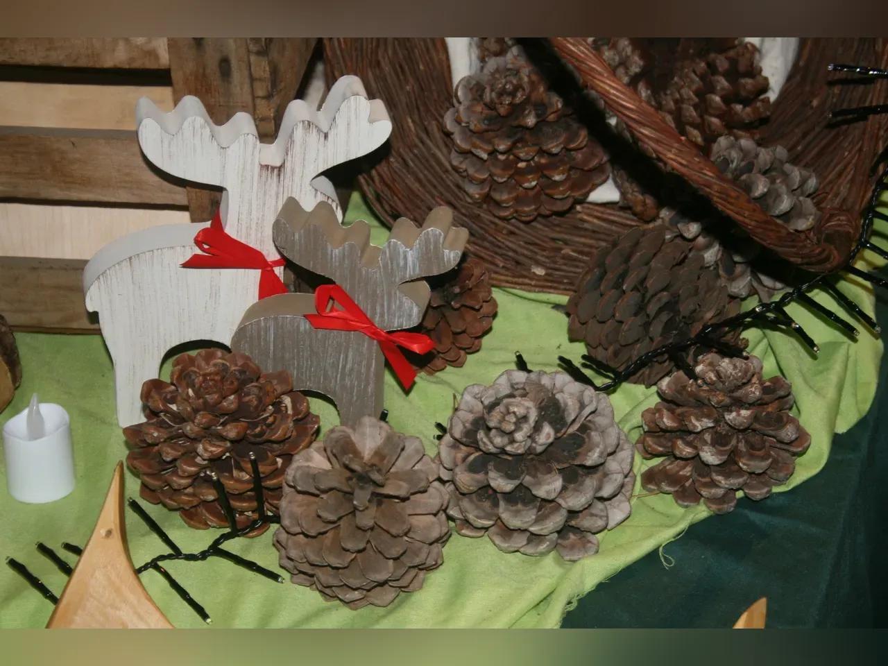 Adventsdekoration mit Tannenzapfen und Holzfiguren in Elch-Form